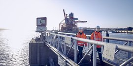 Drei Mann in einem Hafen