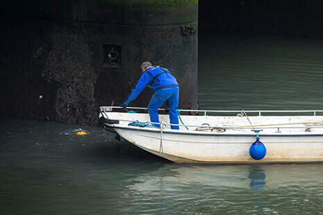 Mitarbeiter im Boot der nach seinem abgetauschten kollegen im Wasser schaut