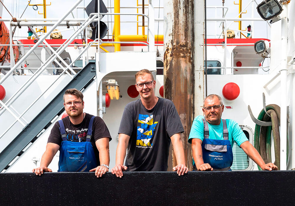 Gruppenfoto von drei Matrosen an Deck der Seelöwe