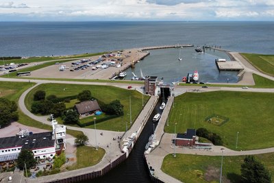 Schleuse im Hafen Hooksiel aus der Luft mit Nordsee im Hintergrund