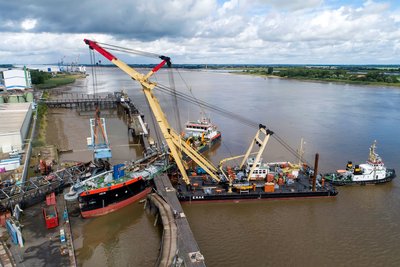 Schwimmkräne heben den havarierten Schiffsbelader im Braker Hafen, 1. August 2025. (Foto: Burmann/NPorts)