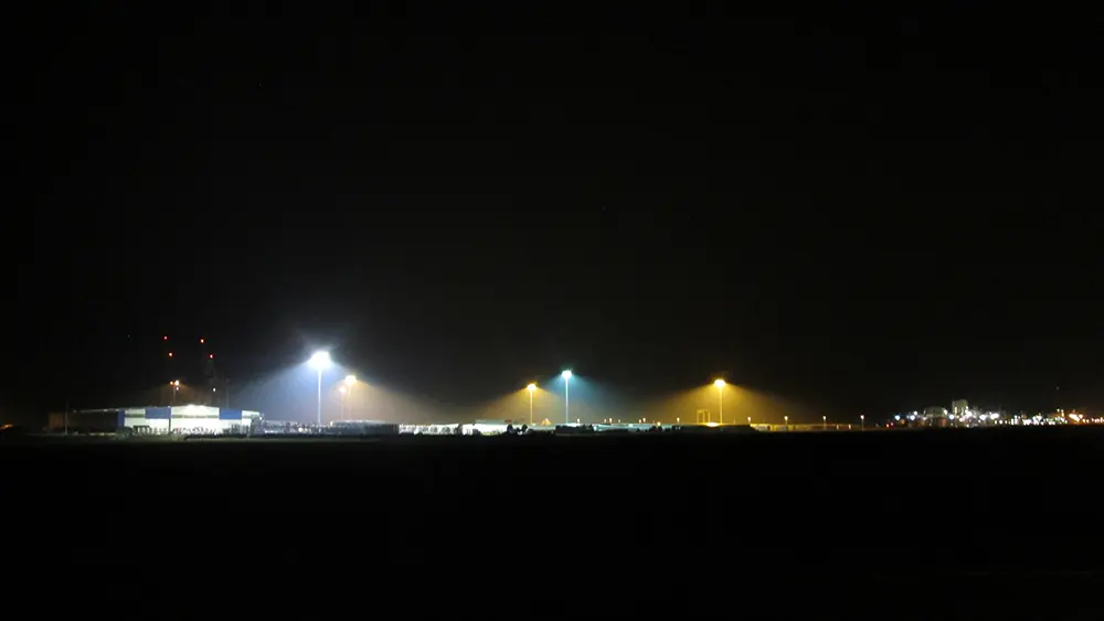 Nachtaufnahme des Hafens Brake während der LED-Umrüstung: Neue LED-Leuchten strahlen weiß, daneben leuchten noch alte Natriumdampflampen in Gelb.