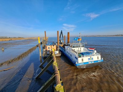 Das Baggerschiff „Ibis VII“ liegt an der Spülstation am Niedersachsenkai an und übergibt das entnommene Sediment über eine Pumpstation und Spülleitungen auf das Spülfeld. (Bild: NPorts)