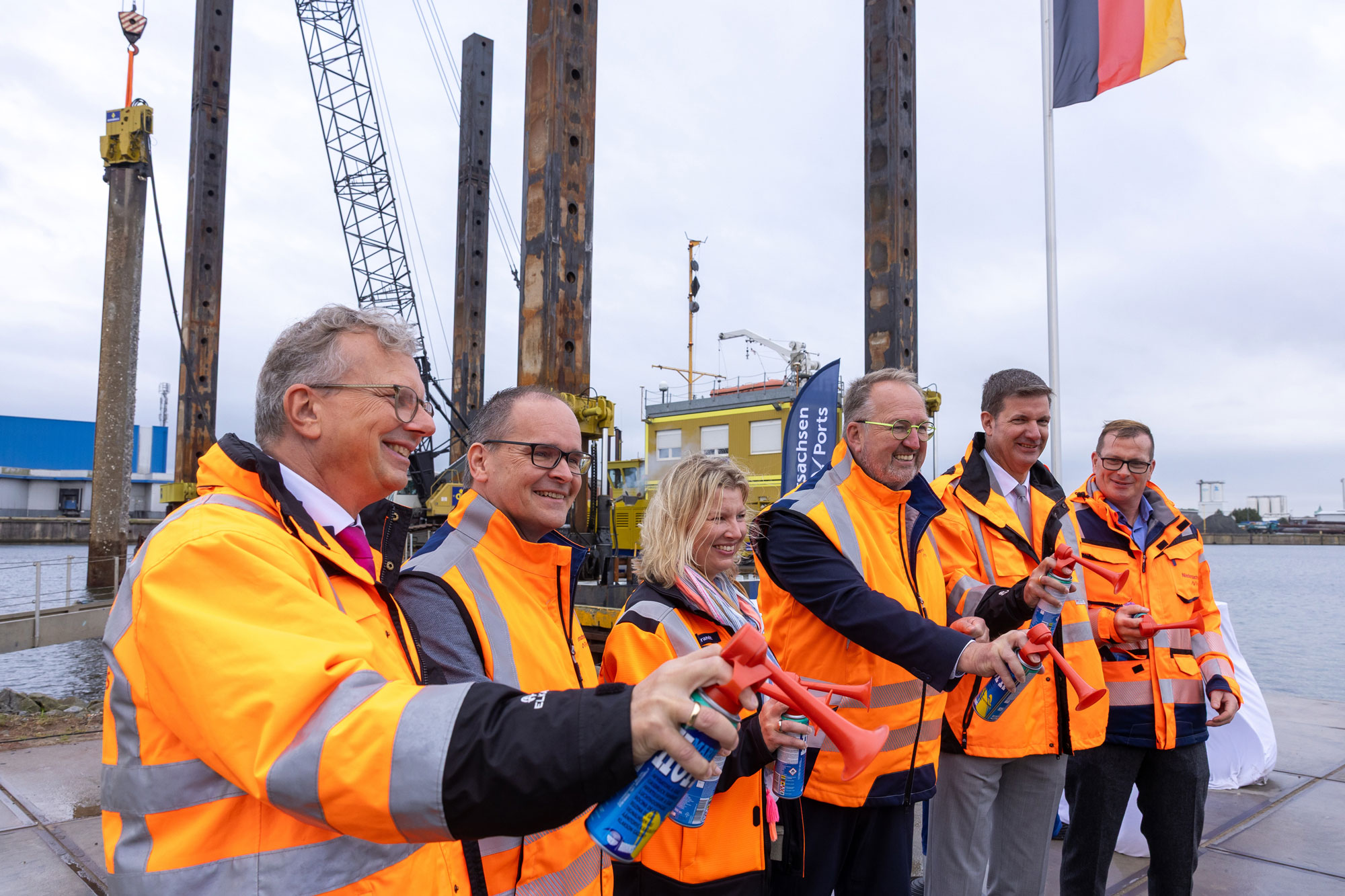 Holger Banik (Geschäftsführer der Niedersachsen Ports GmbH & Co. KG): Grant Hendrik Tonne (Niedersächsischen Minister für Wirtschaft, Verkehr; Alexandra Brandt, (stv. Niederlassungsleiterin Cuxhaven und Stade der  Niedersachsen Ports); Uwe Santjer (Oberbürgermeister der Stadt Cuxhaven) Volker Weiß (Geschäftsführer der Niedersachsen Ports); Knut Kokkelink (Niederlassungsleiter Cuxhaven und Stade der Niedersachsen Ports starten lautstark die Bauarbeiten am Hansakai.