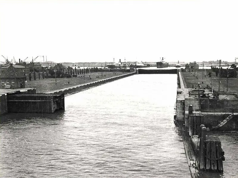 Historisch: Schleusenkammer mit Wasser Historische Schwarz-Weiß-Aufnahme der gefluteten Schleusenkammer der Großen Seeschleuse Emden mit Schleusentor und Schiffen im Hintergrund.